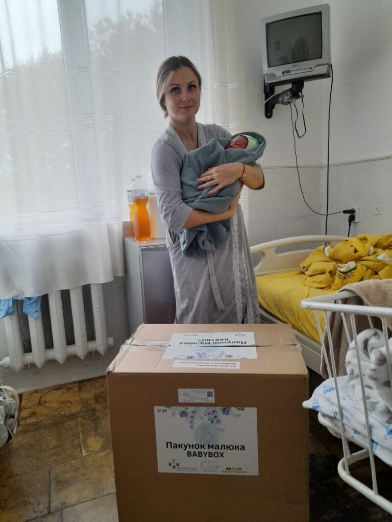 Mutter mit Baby und Babybox des Blau-Gelben Kreuzes