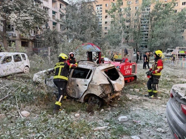 Feuerwehr an einem zerstörten Auto in Kyjiw Ukraine